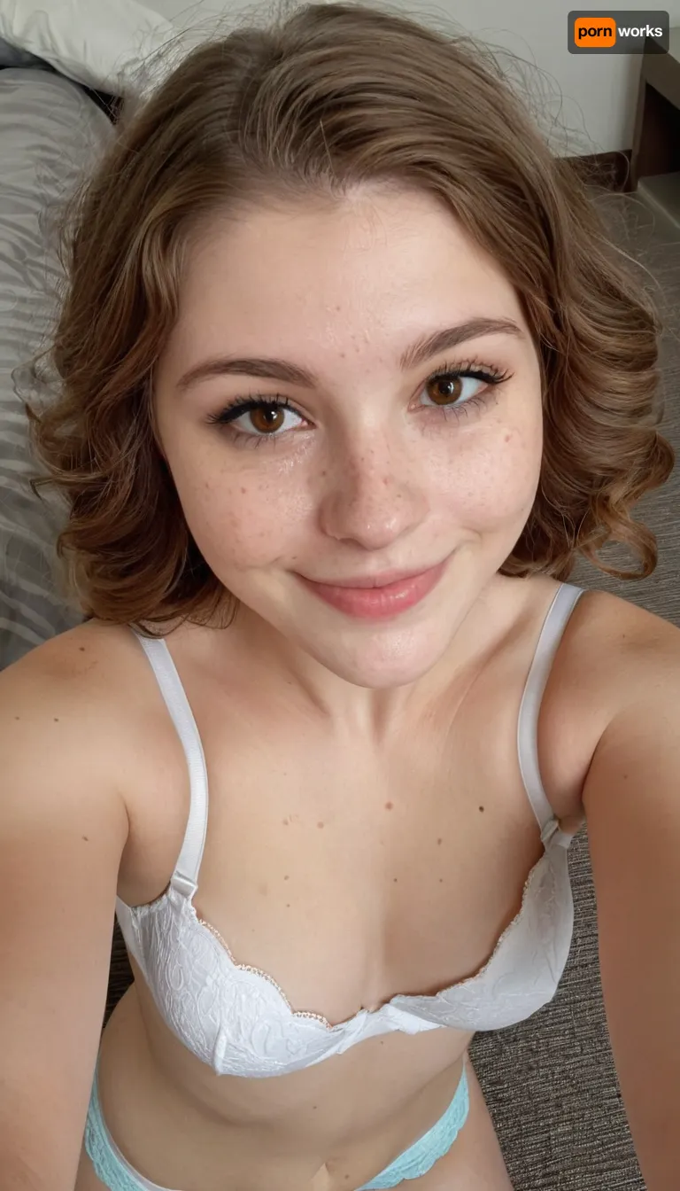 View from above, 22 years old Mexican-american woman, taking a selfie, wearing brassiere, white and pale skin, slim nose, brown hair, small sagging breasts, robust body, embarrassed smile, round face, wearing underwear, minimalist white luxury hotel, short wavy hair, freckles, brown eyes, molar on cheek, 3/4 body view, rhinoplasty, hyper realistic photo, full hd, 8K