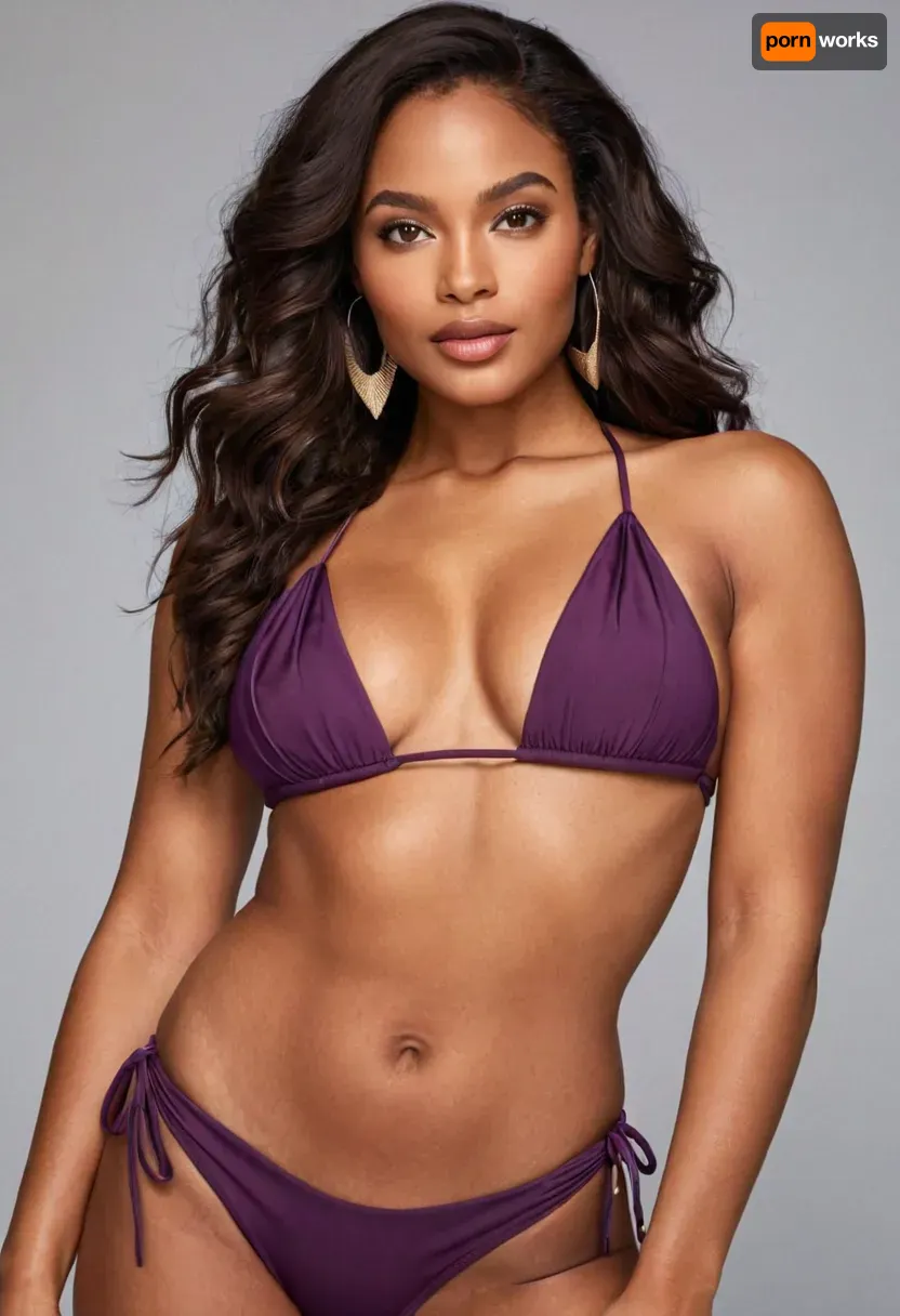 Close-up portrait of a dark-skinned woman, young adult age range. She displays a confident, alluring pose, with a captivating gaze directed at the viewer. Her dark, long hair is styled in loose waves. Her makeup is defined, with accentuated eyes and a soft, natural lip color. She wears a stylish, deep purple, smooth-material bikini. The top is a triangle-shaped bikini top, fitting snugly with a subtle decorative element. The bottoms are high-waisted, featuring ties at the sides, adding a modern touch. The color of the bikini is a rich, showcasing a sleek, modern style. The lighting is soft and well-balanced, casting no harsh shadows, emphasizing the curves of her body. The composition is centered, drawing attention to her figure. The skin tone is medium-dark brown with a natural glow, highlighting her physical features. Her expression is sensual and serene, embodying a subtle sense of confidence. The background is a light gray-beige wall, with a hint of a kitchen area visible in the back. The textures of the skin and the material of the swimwear are smooth and glossy. The atmosphere is alluring, romantic, and inviting. The mood is sensual but not overtly suggestive. The style is contemporary, portrait-style photography, utilizing a close-up perspective with a well-defined focus on the subject. Studio lighting is used, with a focus on creating soft highlights and subtle reflections. Close-up portrait of a dark-skinned woman, young adult age range. She displays a confident, alluring pose, with a captivating gaze directed at the viewer. Her dark, long hair is styled in loose waves. Her makeup is defined, with accentuated eyes and a soft, natural lip color. She wears a stylish, deep purple, smooth-material bikini. The top is a triangle-shaped bikini top, fitting snugly with a subtle decorative element. The bottoms are high-waisted, featuring ties at the sides, adding a modern touch. The color of the bikini is a rich, showcasing a sleek, modern style. The lighting is soft and well-balanced, casting no harsh shadows, emphasizing the curves of her body. The composition is centered, drawing attention to her figure. The skin tone is medium-dark brown with a natural glow, highlighting her physical features. Her expression is sensual and serene, embodying a subtle sense of confidence. The background is a light gray-beige wall, with a hint of a kitchen area visible in the back. The textures of the skin and the material of the swimwear are smooth and glossy. The atmosphere is alluring, romantic, and inviting. The mood is sensual but not overtly suggestive. The style is contemporary, portrait-style photography, utilizing a close-up perspective with a well-defined focus on the subject. Studio lighting is used, with a focus on creating soft highlights and subtle reflections.