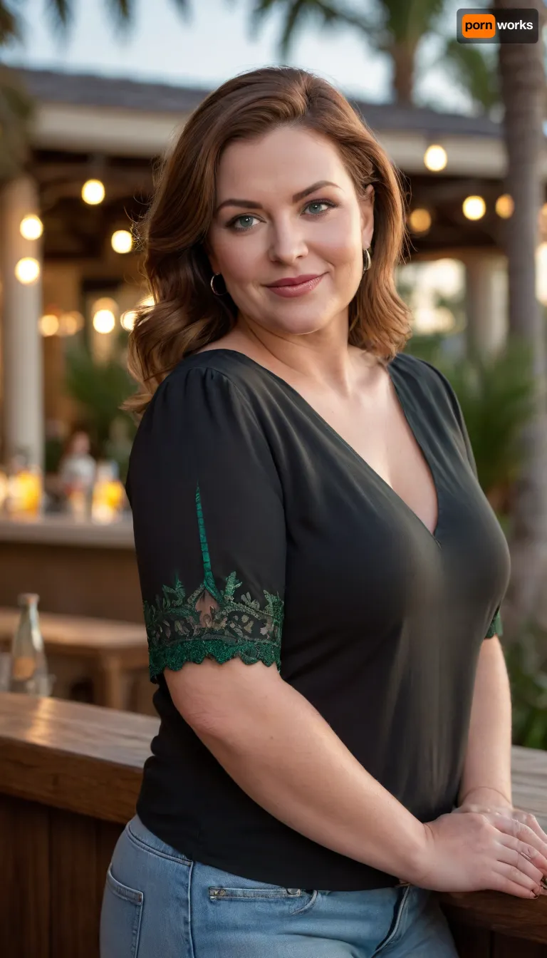 Photorealistic image of a mature, full-figured Mediterranean woman standing at an outdoor cocktail bar at a luxury resort during golden hour. She has shoulder-length chestnut brown hair with silver strands, expressive light blue-green eyes, soft fine lines, and full lips. She wears a fitted black blouse with short sleeves and dark-wash high-waisted jeans that hug her curvaceous figure, including a soft midsection and shapely thighs. Her wedding ring with a large diamond is visible on her left hand. She stands facing the viewer with a warm smile, her posture relaxed and inviting. The bar behind her glows with soft amber light, surrounded by palm trees and resort architecture. The mood is cinematic and emotionally open.