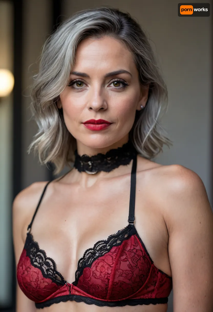 a 50 years old woman, A close-up portrait of a woman, captured in a candid moment. She is adorned in a red and black lace bralette, paired with a black choker featuring a silver buckle. Small perfect tits. The woman's pose is relaxed, with one arm resting on a gray surface, and her gaze is directed towards the camera. The background is blurred, emphasizing the subject, and the overall color palette is dominated by red, black, and silver., detailifier