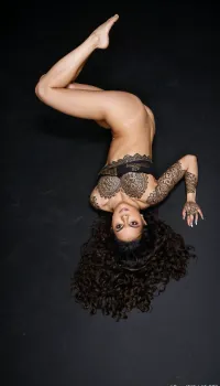 Super realistic, super quality, super detailed. Yasmina Khan, hazel eyes, raven black wavy hair, soft body, l, front view, mehndi tattoo, black background, full, body, all, fours, kneeling, spread, legs, top-down, bottom-up, single, leg, stepped, on, head, ground, <lora:SteppedOnHead-anxl31-000099:.8>