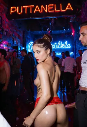 Puttanella, a young Italian girl, is at a nightclub when she meets several men who are interested in her. They take her to the dance floor and begin to fuck her hard. The picture shows Puttanella with a maximum of five