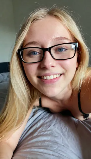 candid photo, confident 18 year old girl, lingerie, soft body, babyfat, small breasts, flat chest, long blonde hair, ((wide jaw)), ((big chin)), thin lips, big nose, eyeglasses, small body, she is laying next to you in bed, someone else in bed off-screen, dark pastel colored bedroom, cute smile, ultimate realism, poor lighting, at night, dark, night, realistic detailed skin texture, focus on realistic face, stunning eyes, skin pores, ultra realism