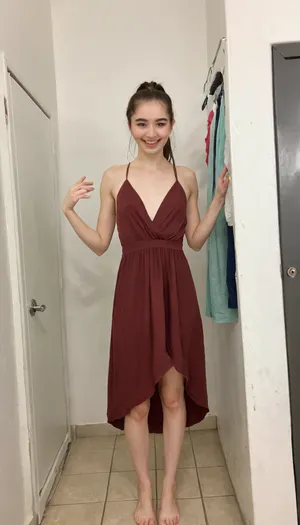 pov, A young slender petite timid college girl of 1m70 height standing in a clothing shop changing stall, indoor, topless long gala dress, deep v-neck, smiling at me, medium length brown straight hair, her hair in a loose ponytail. playful, realistic skin with many moles and imperfections, Detailed natural skin and blemishes without-makeup, acne, showing off her new outfit, thin figure, <lora:skin_4-000015:.3>