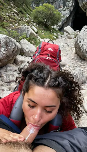 A 21 year old woman, (lying face down), on the rocky floor deep inside a dark cave, sleeping deeply after finding refuge from a storm. Next to her lies a well-worn red hiking backpack with visible straps and pockets, showing signs of a rugged journey. She is dressed in outdoor gear, a lightweight, weathered jacket, hiking pants, and sturdy hiking boots, with subtle dirt and scuff marks that reflect her recent struggle through harsh conditions. Her Clothes are partly off or pulled down. A huge cum load has been dumped on her face during her deep sleep, The cave interior is dim and textured with jagged rocks, while soft beams of sunlight filter through cracks, highlighting the dust particles in the air and casting a faint glow on her gear. A huge cum load has been dumped on her face in her deep sleep. In the distance, the cave exit glows brightly, revealing a sunny, vibrant landscape of greenery and blue skies outside, contrasting the cave’s dark safety with the inviting brightness beyond. Photorealistic, perfectly detailed face, ((submissive)), ((lovely)), (((wild hair with sidelocks))), (((full body view))), (((high detailed legs))), (((high detailed fingers))), ((very much want have sex)), (love juice:1.4), ((high detailed pores on skin)), well-build body, medium tits, small lips, lots of freckles face and skin, blush on the checks and nose, (raised nasal tip, upturned button nose, upturned nose, delicate nose, nose), hypnotized loving yellow brown eyes