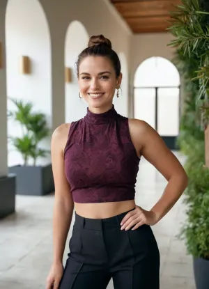 The image is a medium shot featuring a woman posing indoors. She is the central figure, positioned slightly off-center to the left. Her hair is pulled back in a bun. She wears a black, sleeveless crop top and wide-legged pants with a paisley pattern in shades of burgundy, white, and gray. Her right hand is on her hip, and she is smiling. A black watch is visible on her left wrist.

The image features a beautiful very sexy 47yo woman. Eva in paradise. Cinematic. Body according to age with imperfections like Cellulite, Varicose veins etc. Oval face. Pale skin, no tan. Height 170cm. Breast size 80C. Smiling. Dark brunette hair, ponytail, hair parted on one side. very high forehead. thinning hair with little volume, hair combed back tucked behind ears. Slightly curvy body. Stocky legs. Nice round ass. Narrow waist, Sturdy thighs, little tummy, wide very female hips, Decent makeup. She likes to show skin. Small eyes. Thin eyebrows. Wrinkled eyes. Beautiful capturing woman. Smiling. She is very aware of her sexual charms and uses them to seduce others.

The person in the image is a young woman with fair skin. Her hair is pulled back in a bun. She is wearing a black, sleeveless, high-neck crop top and wide-legged pants with a paisley pattern in shades of red, and purple. She has one hand on her hip. She is smiling. She is wearing white sneakers. She is standing indoors.

The background is blurred, suggesting an exterior setting. Visible behind the woman are trees and green. The lighting appears to be warm. The overall composition gives a sense of relaxed confidence.