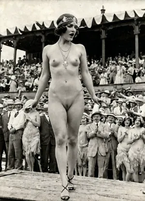 1920年代初,莉莉站在一条穿比基尼和耳环的猫行道上,为相机摆姿势. 她是一个地下色情产业的一部分 多年来在城市里蓬勃发展
