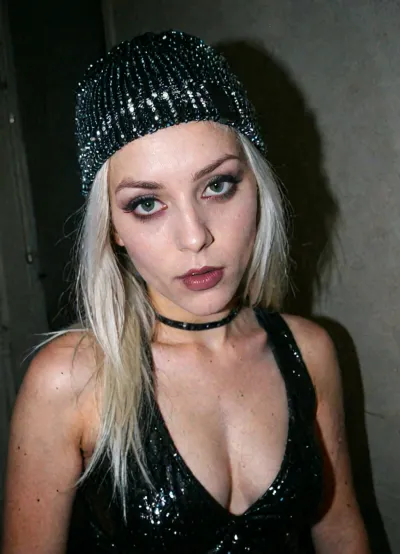 View from below, girl are 4' tall, size 10 waist, slim thick, Leica M10, dslr, Wide-Angle Lens 35mm, ((extremely wide shot:1.8)), (((Wide-Angle perspective:1.8))), (((interesting angle))), (full-length image:1.9), ((rear side view:1.8)), (nighttime), (no ambient light), (single harsh flash from the camera), close-up shot from upper thighs to head, centered composition, detailed lighting, full focus, size 00 waist, closed-Angle Lens 85mm, ((extremely closed shot:2)), (((closed-Angle perspective:2))), ((rear front view:1.8)), (very ambient light), (overexposed flash highlights on subject), (sharp shadows behind and around her), (noise in all darker areas), (wet surfaces reflecting highlights), (flat lighting due to direct flash), (cool white balance:1.3), (yellowish-tinted shadows from digital camera sensor), (fluorescent-like artificial lighting tint), (background remains visible due to flash, but lacks blur or depth separation), (realistic withe environment with high flash contrast), (full body), (scene "Myspace"), (2000s), (90s digital aesthetic), (flat chested), (low quality photo), (old camera), (flash photo), (gritty), (analogic style), (film grain), (low contrast), (unfiltered), (jpeg artifacts), (unedited), (cellphone photography), (no ambient lighting), (lights off), (Polaroid flash camera), (cool indoor lighting), (direct flash photography), (overexposed flash), (strong shadows), (sharp shadows), (low contrast:2), (noise in dark areas), (shiny reflections on surfaces), (sharp background), (background in focus), (no background blur), (clear background details), (fluorescent lighting tint), (yellowish-tinted shadows), (artificial lighting with cyan hue), (Scene-Queen), (optional), (Myspace), (picture), (bad quality), (old digital camera), (raw), (light leak), (low res), (low quality), (90s style), (80s), (analogic), (1990s), ((dark areolas:1.5)), ((dark groin:1.5)), 😂 This photograph features a young woman with fair skin and long, straight platinum blonde hair. She is wearing a glittery, silver knit beanie with a black "XxX" logo and a choker necklace adorned with sparkling rhinestones. Her makeup includes bold, winged eyeliner, false eyelashes, and glossy pink lips. The background is a solid dark teal, making her light-colored attire and accessories stand out. The overall style is modern and edgy, emphasizing a chic, urban look.🤩, <lora:LCMTurboMix_Euler_A_fix:.1>, <lora:beach_wallpaper:.7>, <lora:badquality_v02:.8>, <lora:Polaroidv2:2>