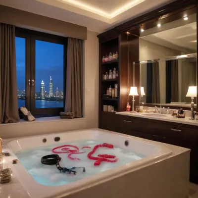 Various types of adult sex toys such as a foreskin imitating a real penis, a black whip, a lace blindfold, ropes, vibrators of various sizes, nipple clamps, various chokers, candles for personal use, ice cubes on top of the luxury wardrobe next door, penis and vagina-shaped candies, all scattered on the luxury bed in the luxury bedroom, with a window overlooking the night city, with a flat-screen TV on, and a luxury bathtub in the luxury bedroom.