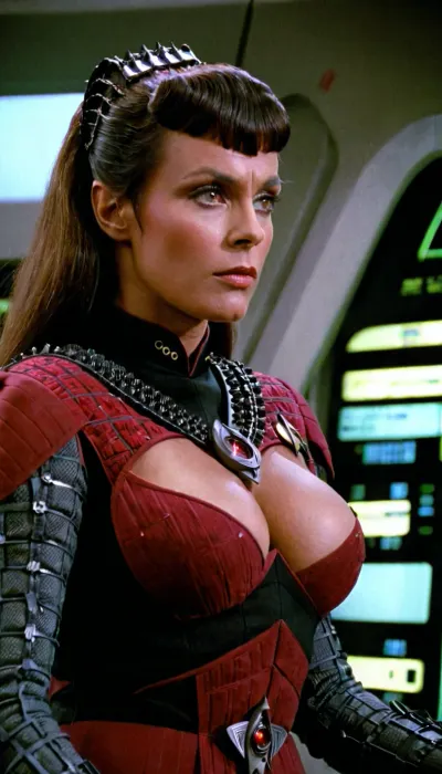 A woman in her early 20s, wearing a red Starfleet uniform armor, was on the Enterprise control panel. She was using the Borg's TNG pornographic pictures as her background while she watched a still of the Klingon Romula