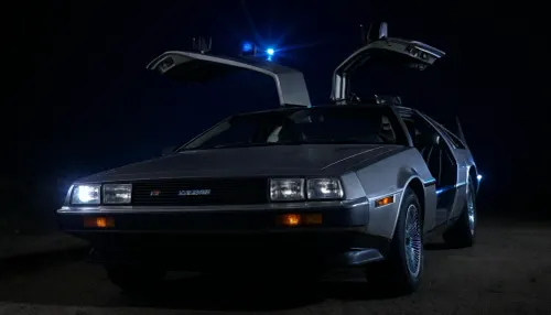 DeLorean from BTTF, (Back to the Future), Night, Dark Sky, Road in Desert, Real Road, Lights of DeLorean, (Travel Time Effects, Driving to 88mph, Driving Effects, Blue Lights on Components Located on the Side of the DeLorean, ((Blue Flash, Blue Flashes from the DeLorean, Blue Fire Flashes from the DeLorean, Lightning Flashes all Around the DeLorean))), Doors Closed, Marty McFly Sits in the DeLorean and Drives it, Side View from Below, <lora:dark:.5>