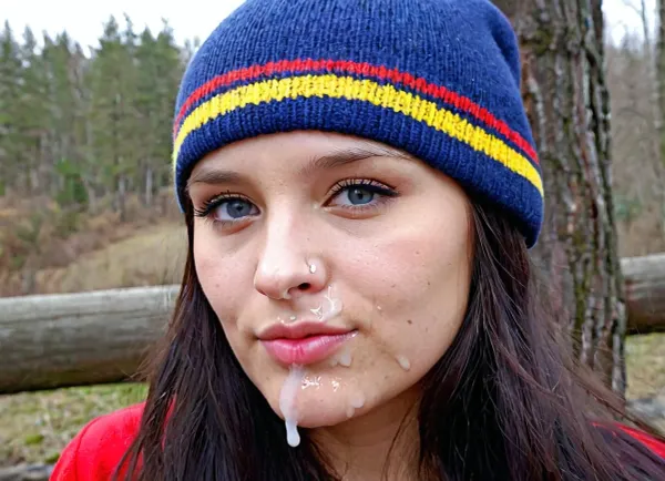 La hermosa mujer Sámi con sombrero tradicional Sami, cara redondeada amplia, cabello suave, una nariz ligeramente volcada recta que es ancha en la base, tono de piel caliente, pómulos altos y pronunciados. Tiene semen en su frente y