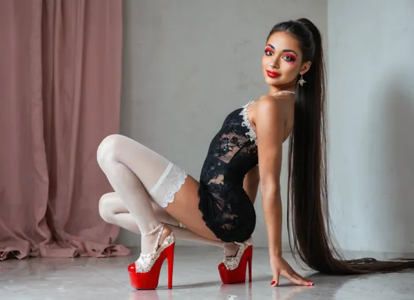 strikingly beautiful woman, slender, very cute tall, (very small breasts), beautiful eyes, open eyes, narrow shoulders, beautiful, attractive, natural beauty, slim latina, very very very long black straight hair, high ponytail, ((black short lace dress)), ((white lace stockings)), ((red platform shoes)), rainbow makeup, deep red lips, ((in her pink room)), he crouches with legs wide apart, with camera in hand, (((he is holding a foto camera in his hand))), whole body visible, delicate smile, (best quality), (realistic, photorealistic), (high detailed skin), soft lighting, sharp focus, high quality, beautiful proportions, (wide hips), round ass, thick, thin arms, natural light, vulnerable, innocent, sexy