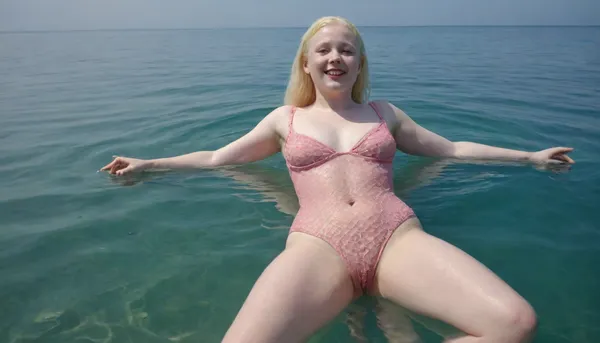 Ukrainian absolutely albino just eighteen-year-old tiny chubby woman, in a mesh pink bodysuit, hairy pussy, barefoot, happily smiling, swimming serenely on her back full-length in a clear blue sea