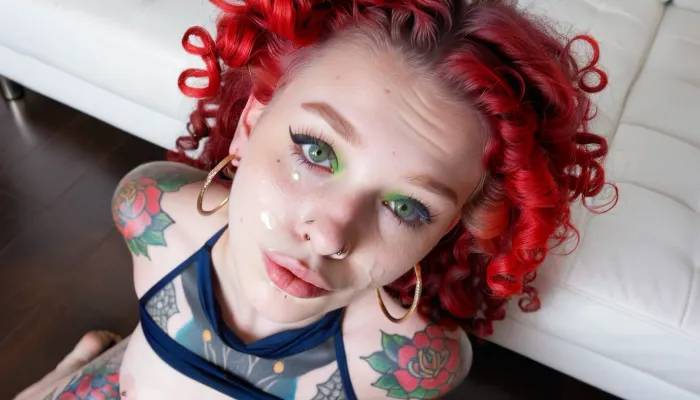 A full body, head-to-toe, shot of a pale skin 18yo Caucasian female with a lot of floral tattoos on her face and body. Her face and body are completely covered with tattoos and piercings. These tattoos are everywhere on her face, on her nose, on her cheeks, on her chin, on her eyelids, on her cheekbones, under and above her lips. These tattoos are mostly of faded blue or navy or black color, not very bright. She has huge hoop earrings She has red blowout hair with big curls. She has green eyes.